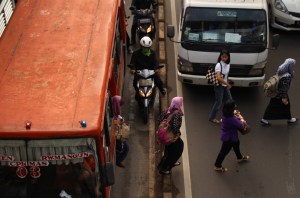 Brain Damage! The orange bus, thier dropped passangers, and bikers are in the wrong place. The left line, seperated by streetline and tiny litle barrier is dedicated way for Jakarta's special Bus called Transjakarta, and this orange bus is not one of them. 